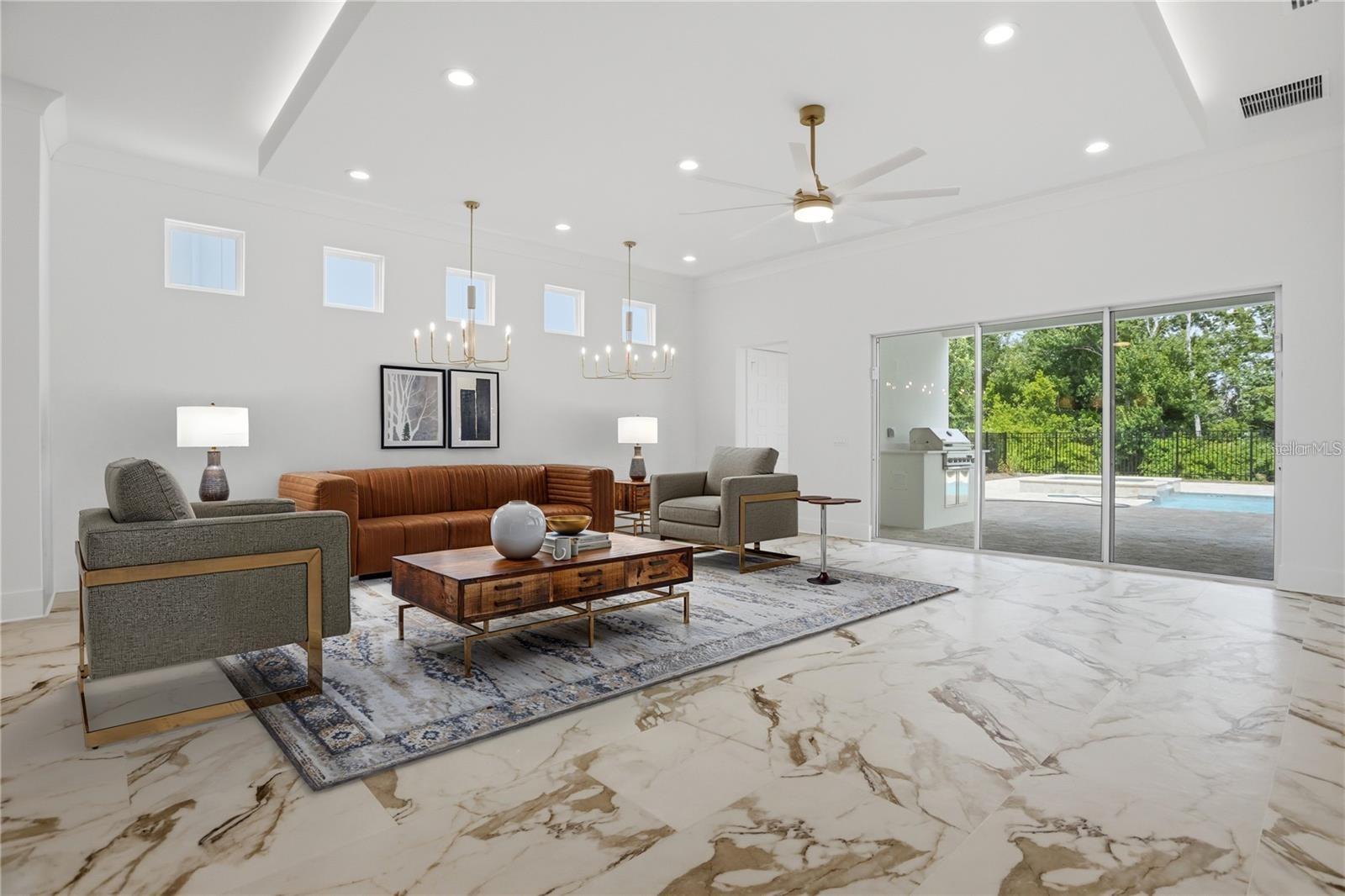 Living room with a vaulted ceiling, marble-look floors, and sliding doors to a patio and pool.