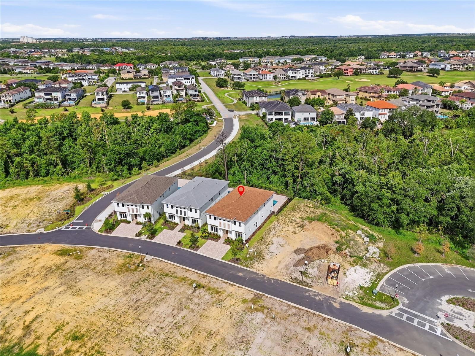 Aerial view of the marked Whitemarsh Way home, with wooded land and a golf course nearby.