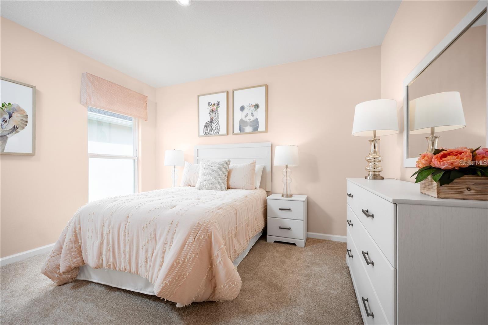 Staged bedroom with pale pink bedding, framed animal prints, and a white dresser.