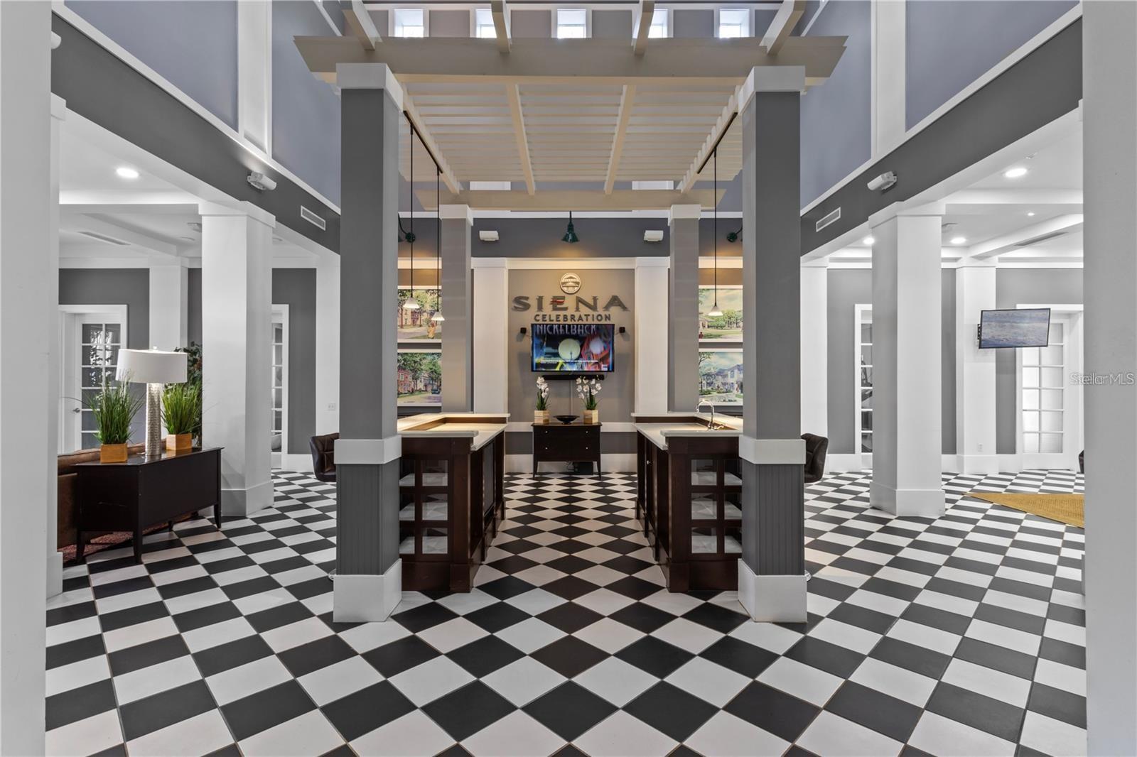 Siena Celebration lobby with checkerboard tile flooring, dark wood counters, and a high beamed ceiling.