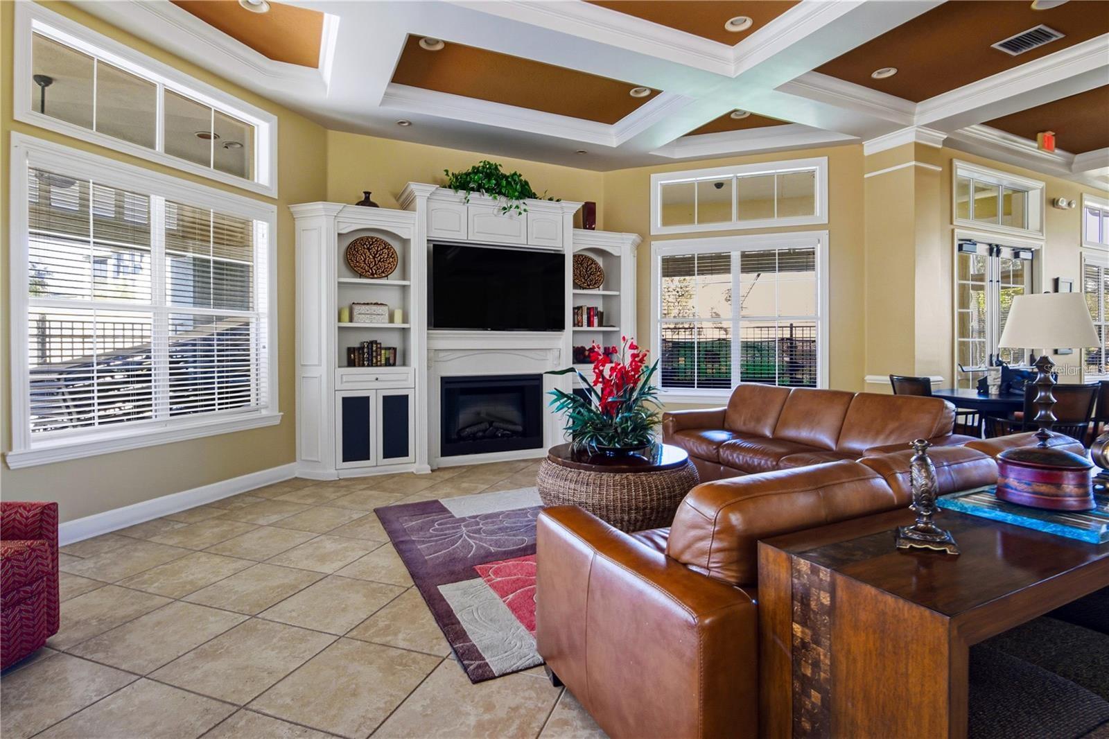 Furnished living room with leather seating, a built-in fireplace and entertainment center, and a coffered ceiling.