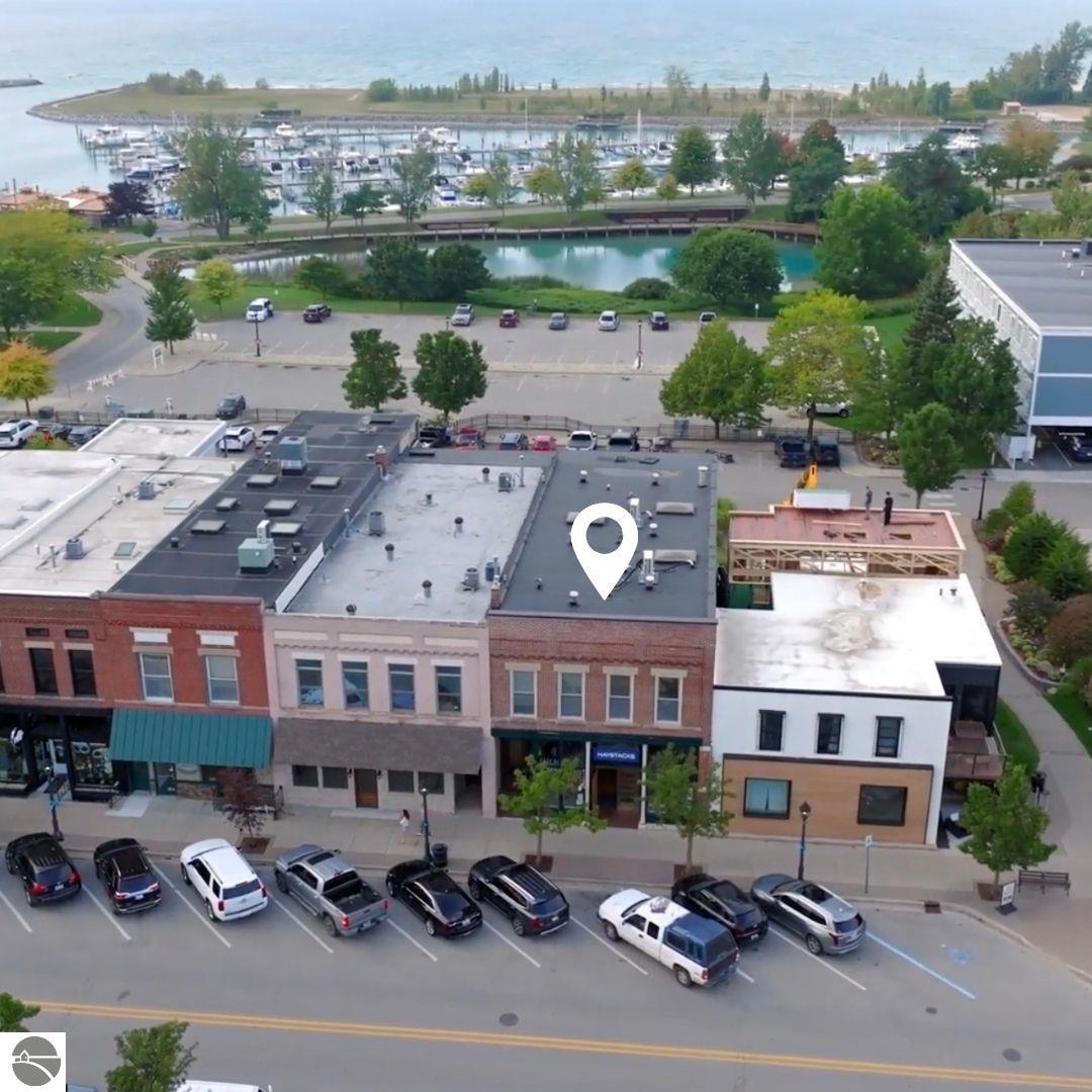 Aerial view of Elk Rapids downtown storefronts, with the marina and Lake Michigan behind them.