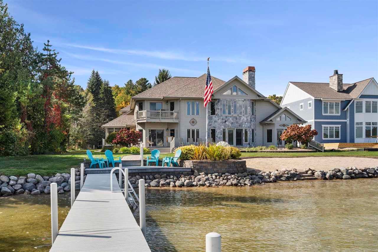 Lakeside home with a stone façade and dock extending into the water.