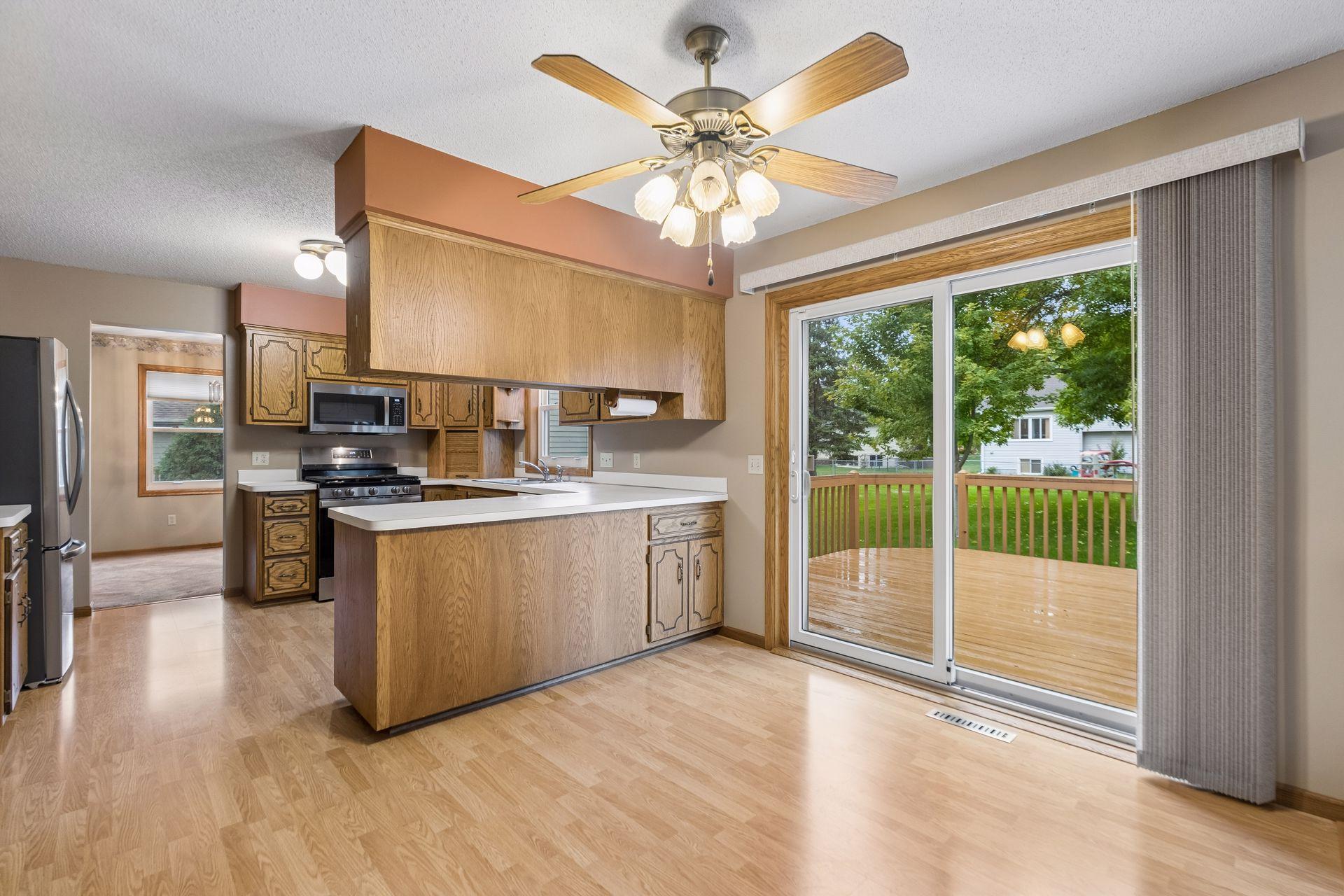 Kitchen with wood cabinets and a peninsula, beside sliding doors opening onto a deck.