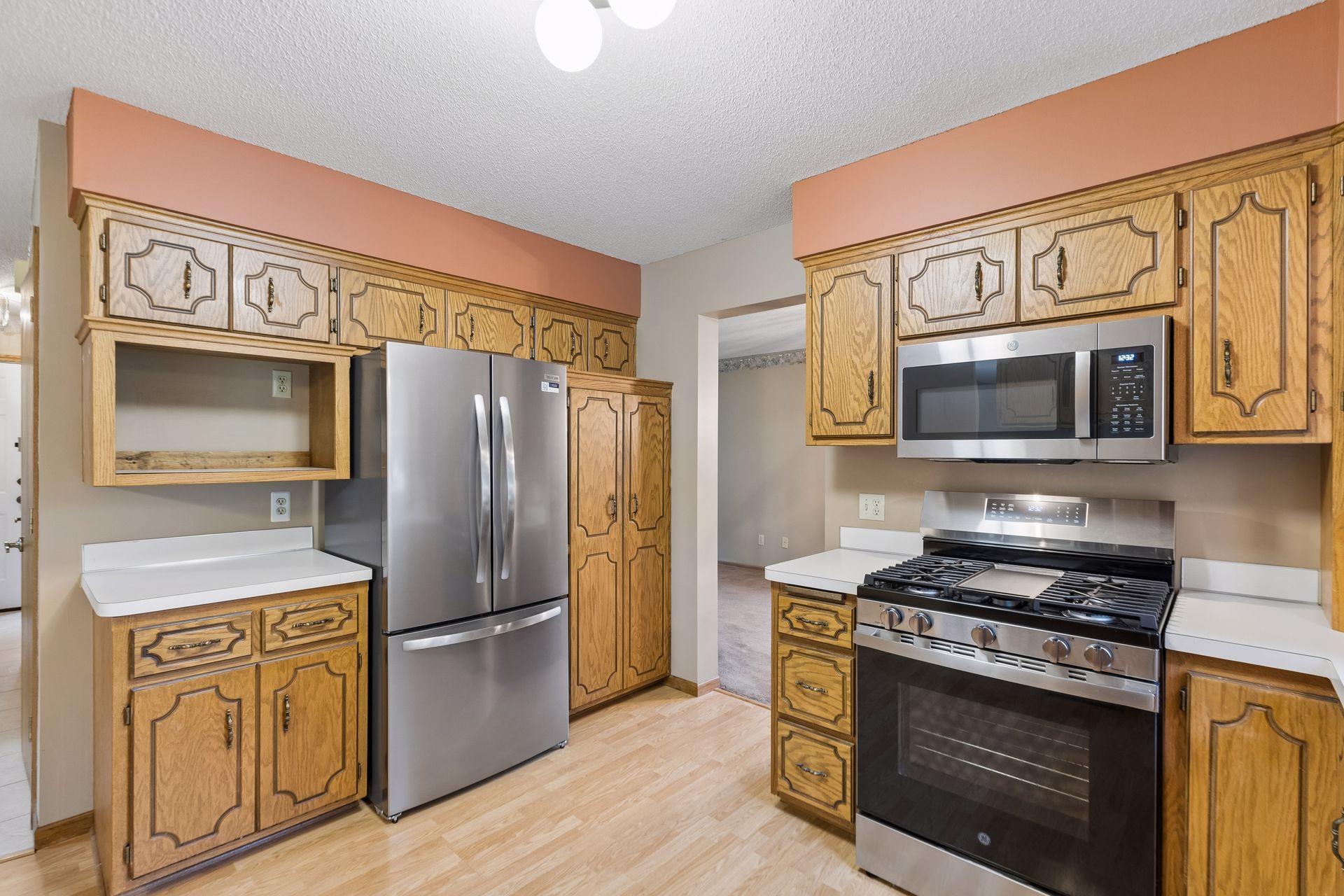 Kitchen with oak cabinets, stainless-steel appliances, and a gas range.