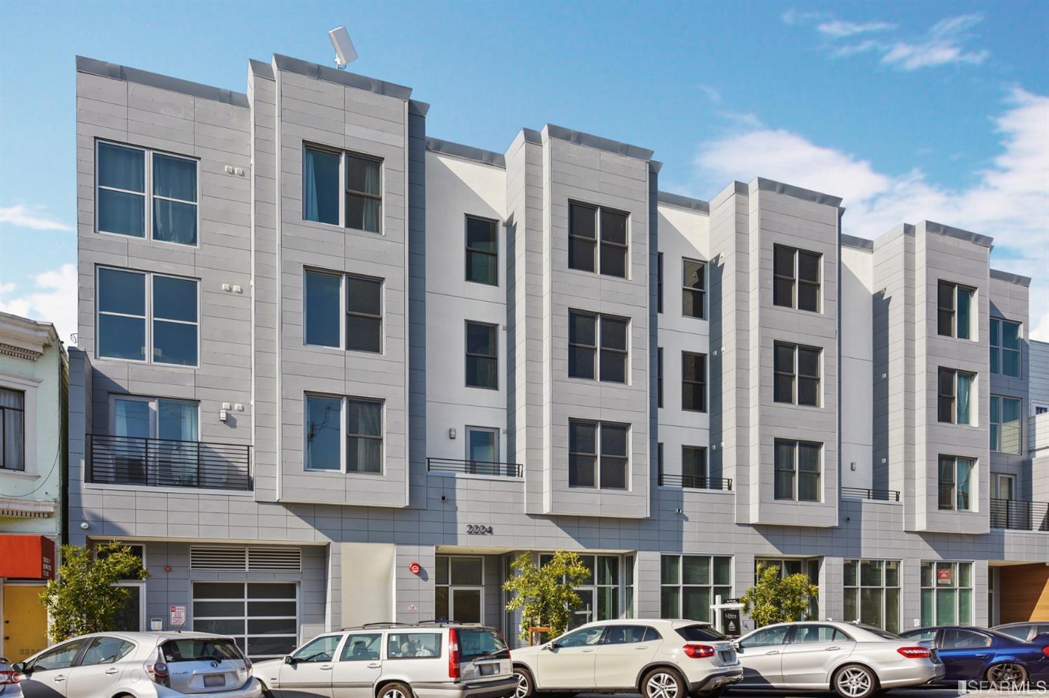 Modern multi-story apartment building at 2224 Clement Street, with parked cars along the street.