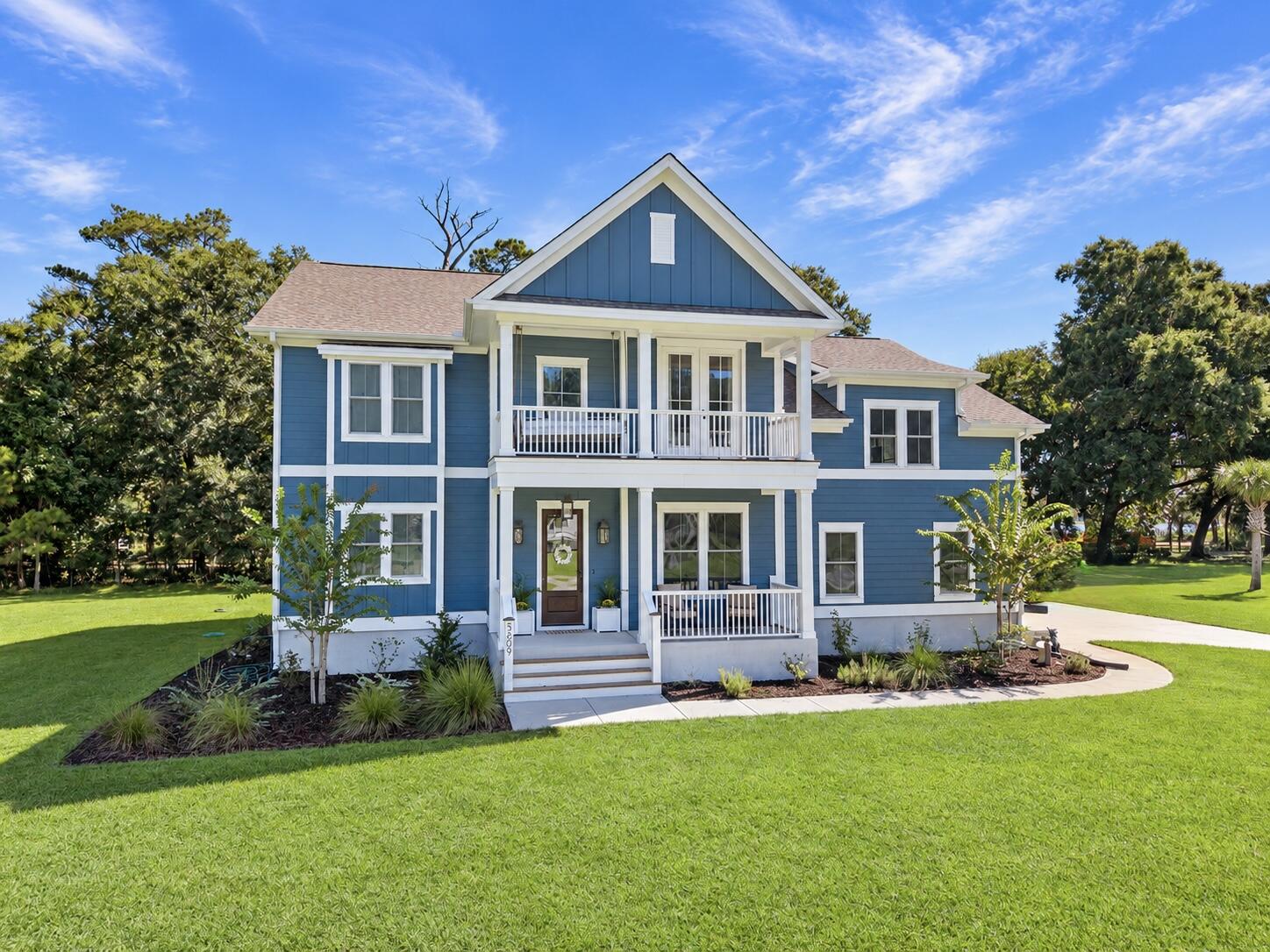Blue two-story house with white trim, a covered porch, and an upper balcony.