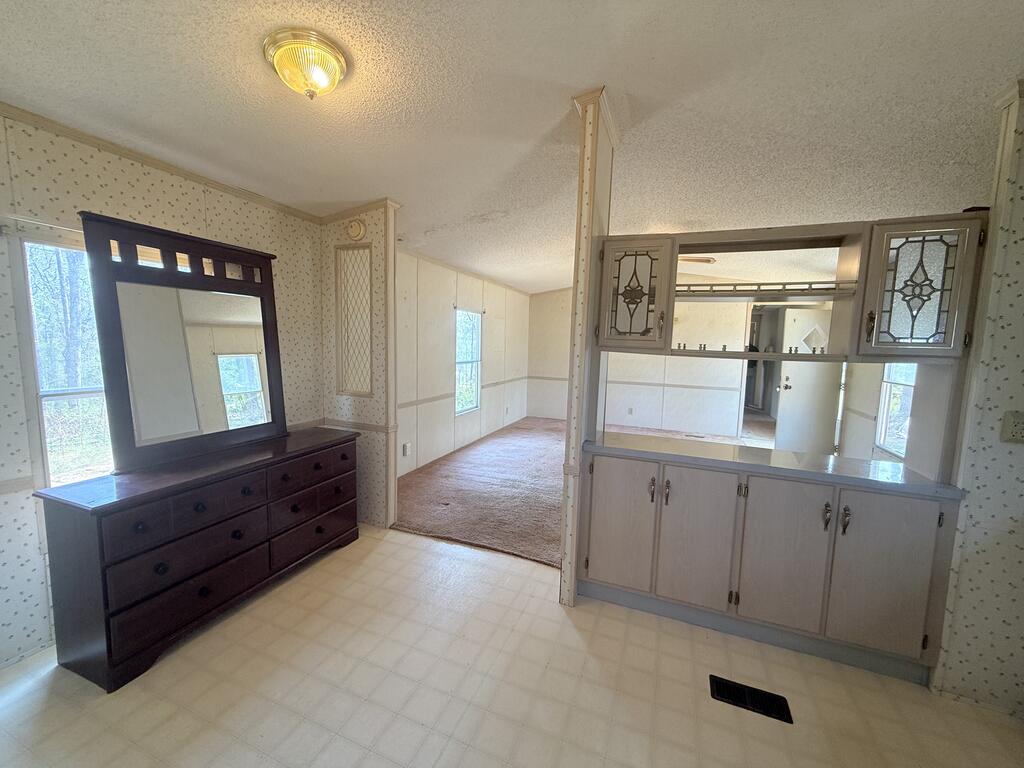Pass-through cabinets connect a room with a dark wood dresser to the kitchen.