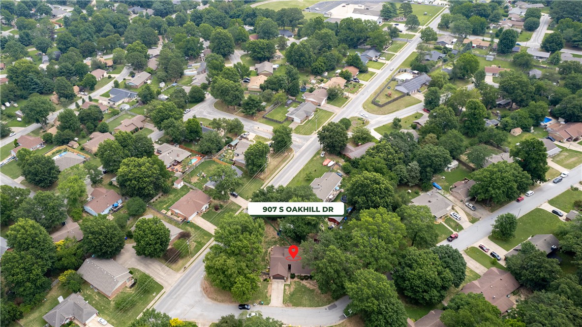 Aerial view of 907 S Oakhill Drive, marked with a red pin among tree-lined residential streets.