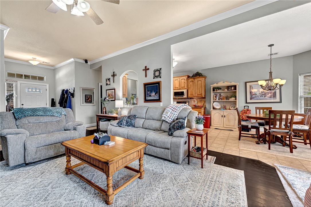 Living room with gray sofas and a wooden coffee table, opening into the dining area and kitchen.