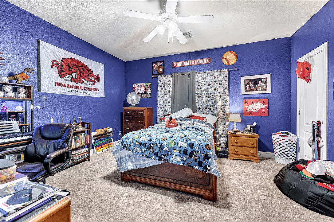 Bedroom with blue sports-themed bedding, vivid blue walls, and sports memorabilia.