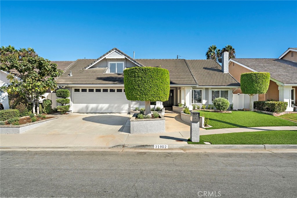 Home at 21902 with a wide driveway, double garage, and neatly trimmed front yard.