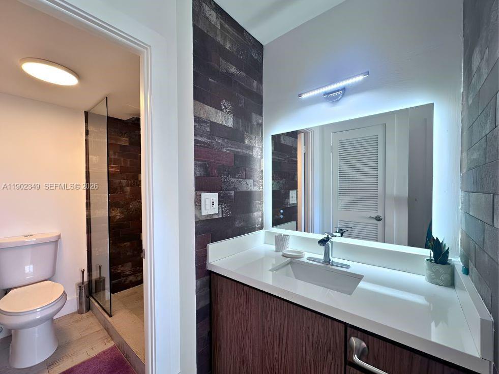Modern bathroom with a wide white vanity, large mirror, and glass-enclosed shower.