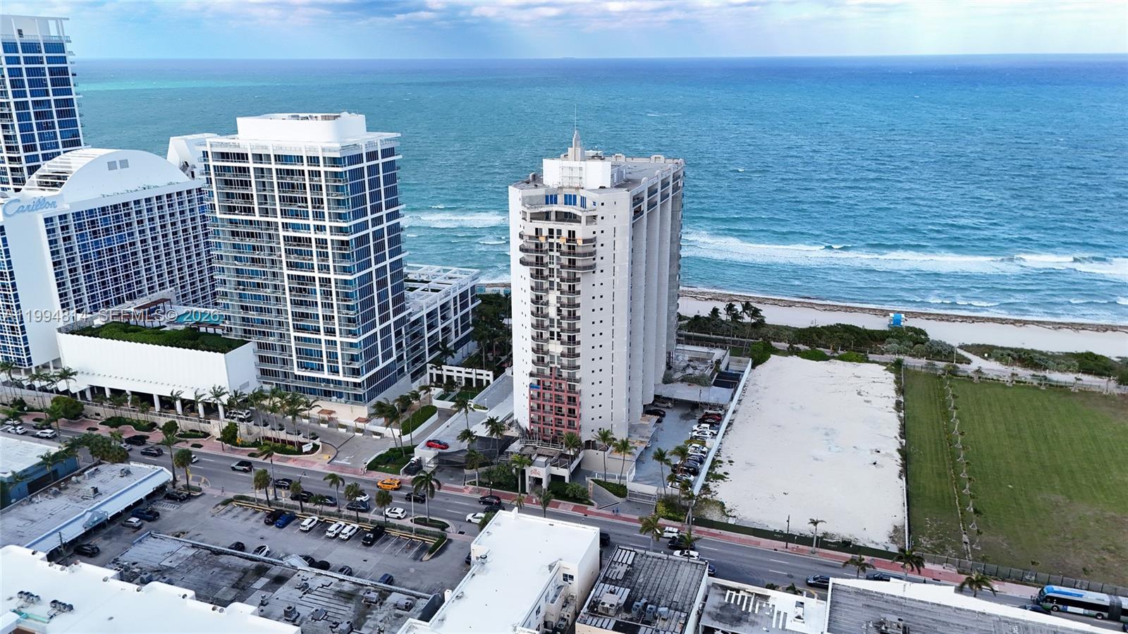 Beachfront high-rises along Collins Avenue beside the Atlantic Ocean and a sandy shoreline.