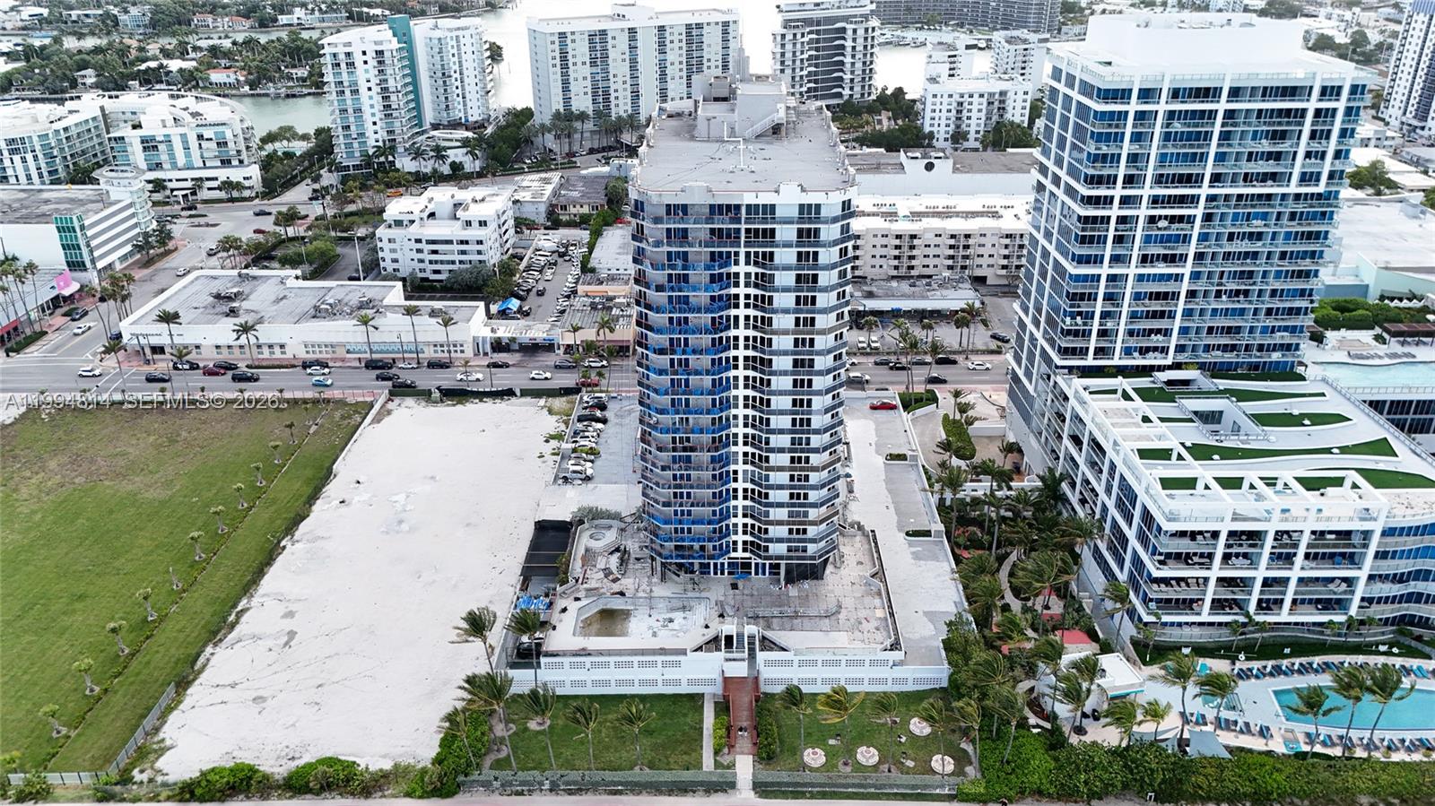 Aerial view of a high-rise condominium under construction among Miami Beach buildings.