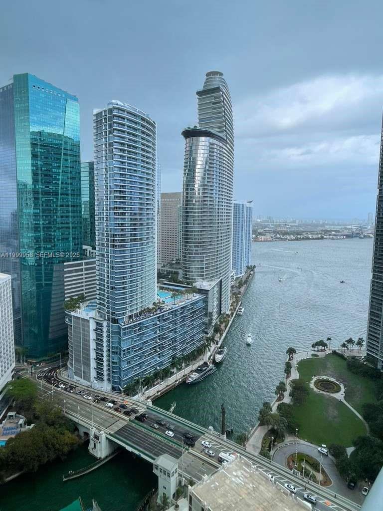 Downtown Miami high-rises along the water, with a bridge and waterfront park below.