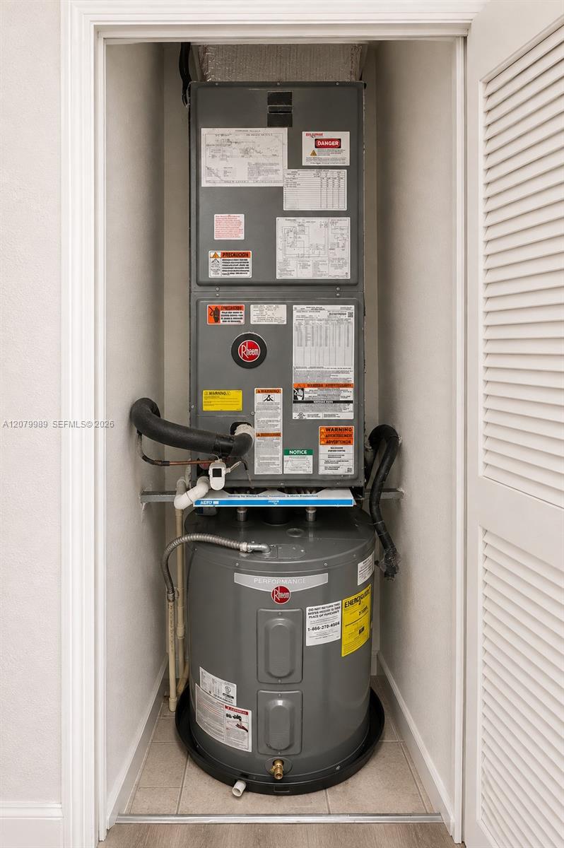 Rheem water heater and HVAC air handler in a narrow utility closet.