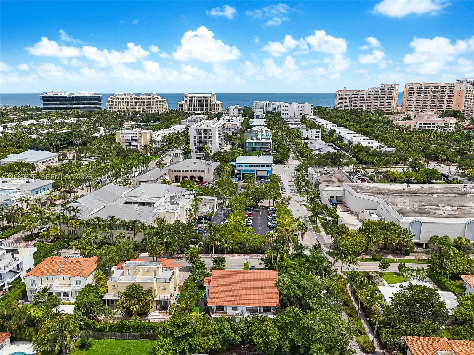 Aerial view of coastal Key Biscayne homes, palm-lined streets, and oceanfront high-rises.