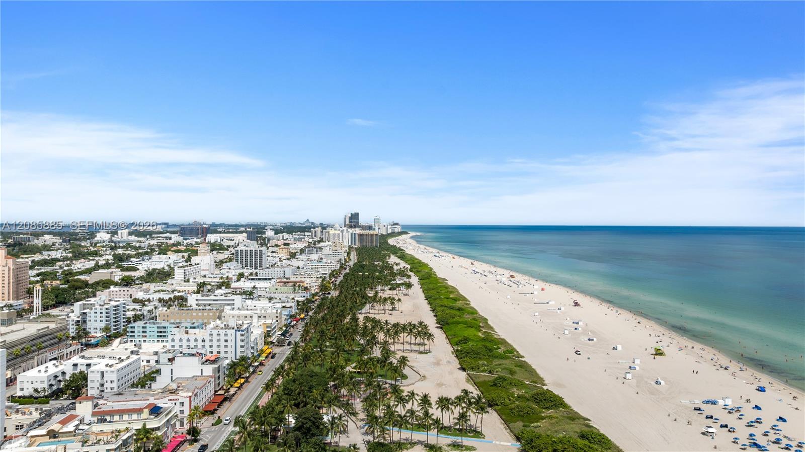Aerial view of Miami Beach's sandy coastline, turquoise water, and beachfront buildings.