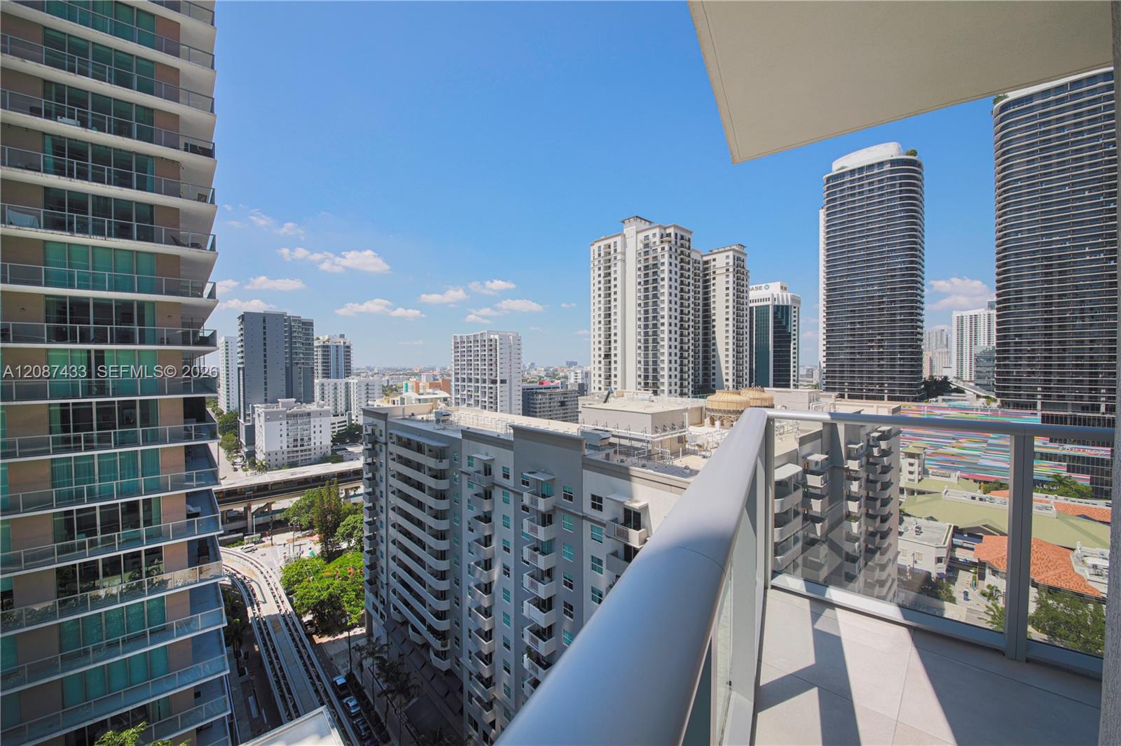 Balcony with a glass railing overlooking Miami’s downtown high-rises.