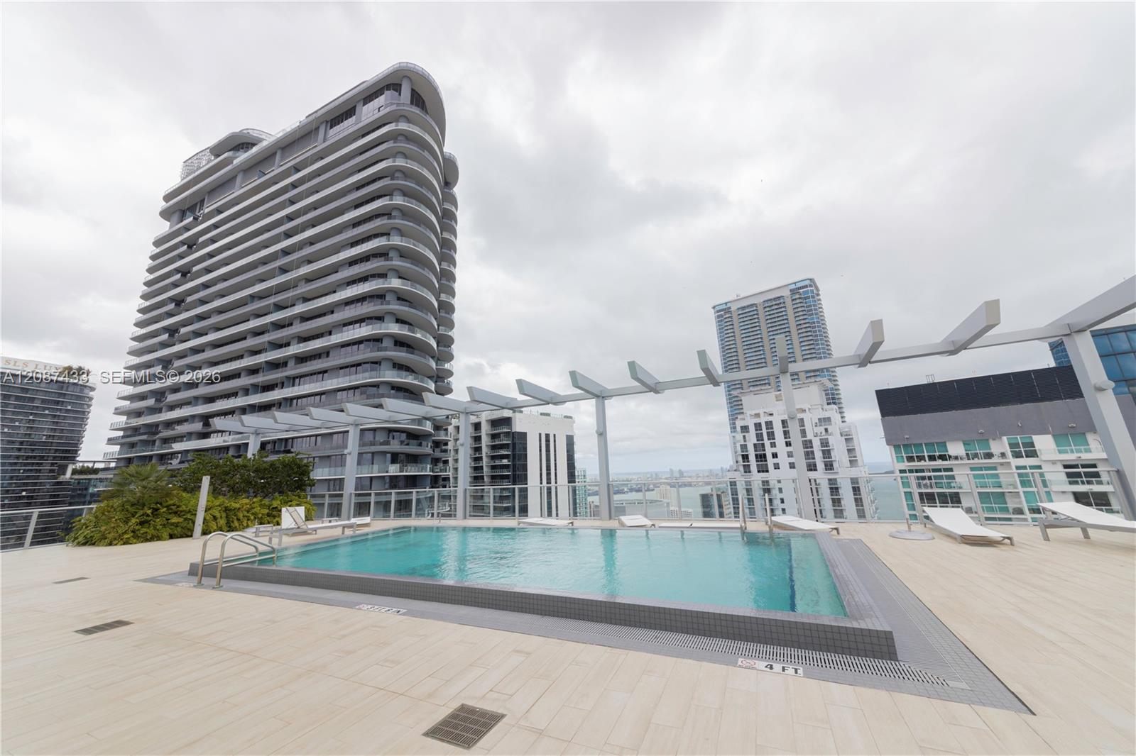 Rooftop swimming pool beside Miami high-rises, with a city and waterfront view.