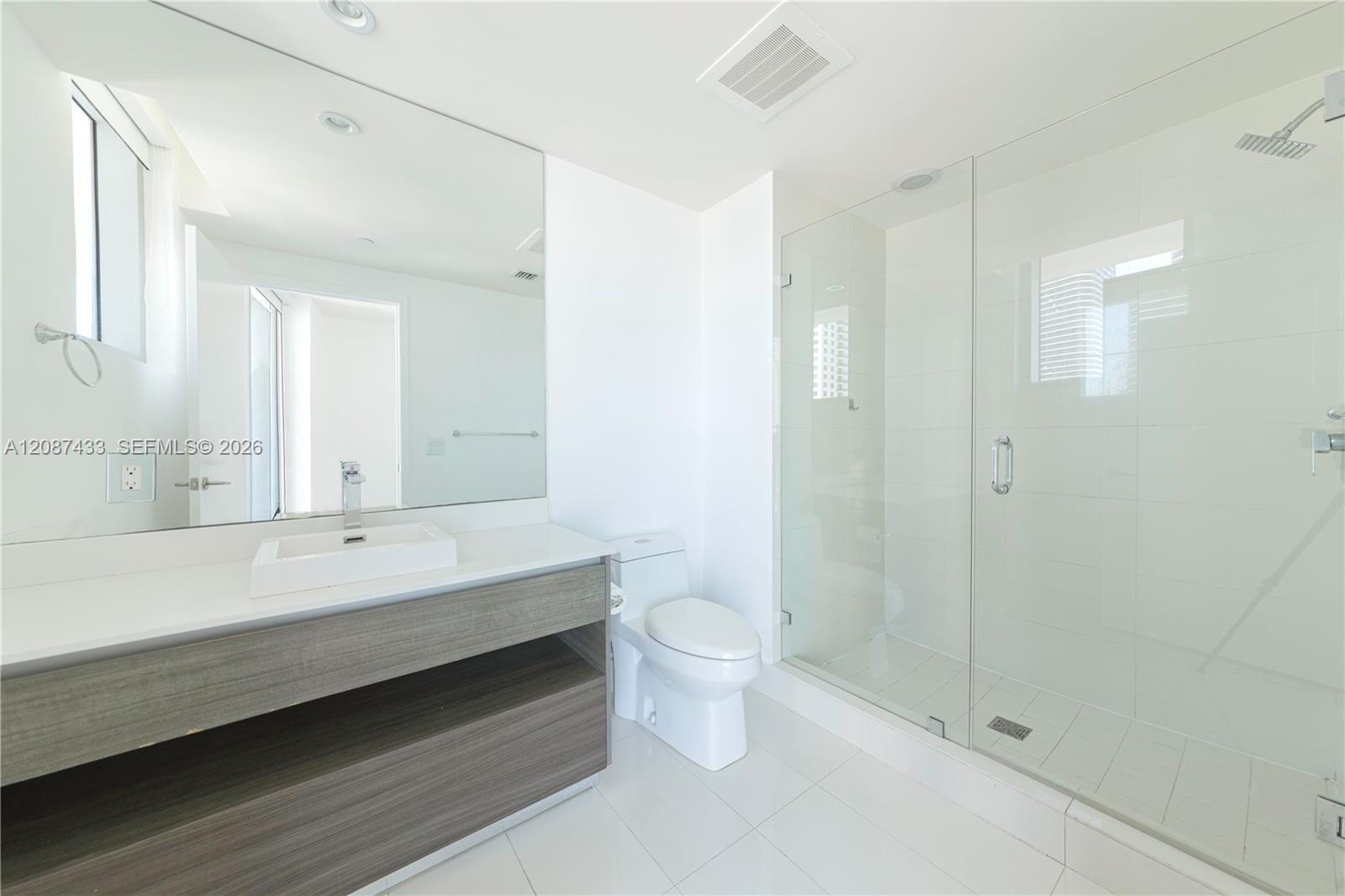 Modern bathroom with a floating vanity and glass-enclosed shower.