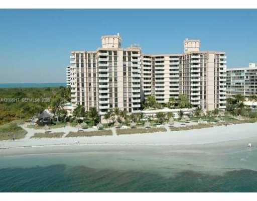 Beachfront condominium complex on Key Biscayne, viewed from above with white sand and turquoise water.