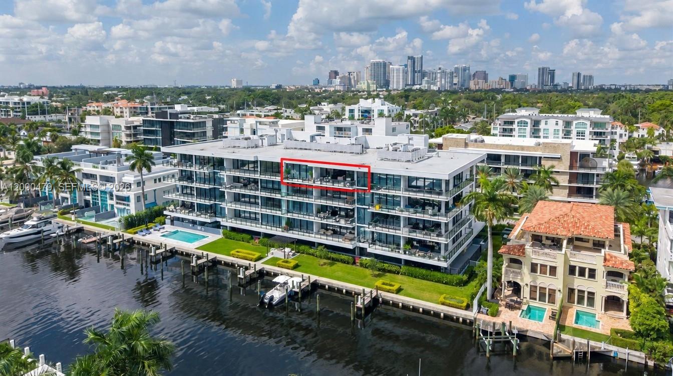 Waterfront condominium with the penthouse outlined in red, canal docks, pool, and Fort Lauderdale skyline.