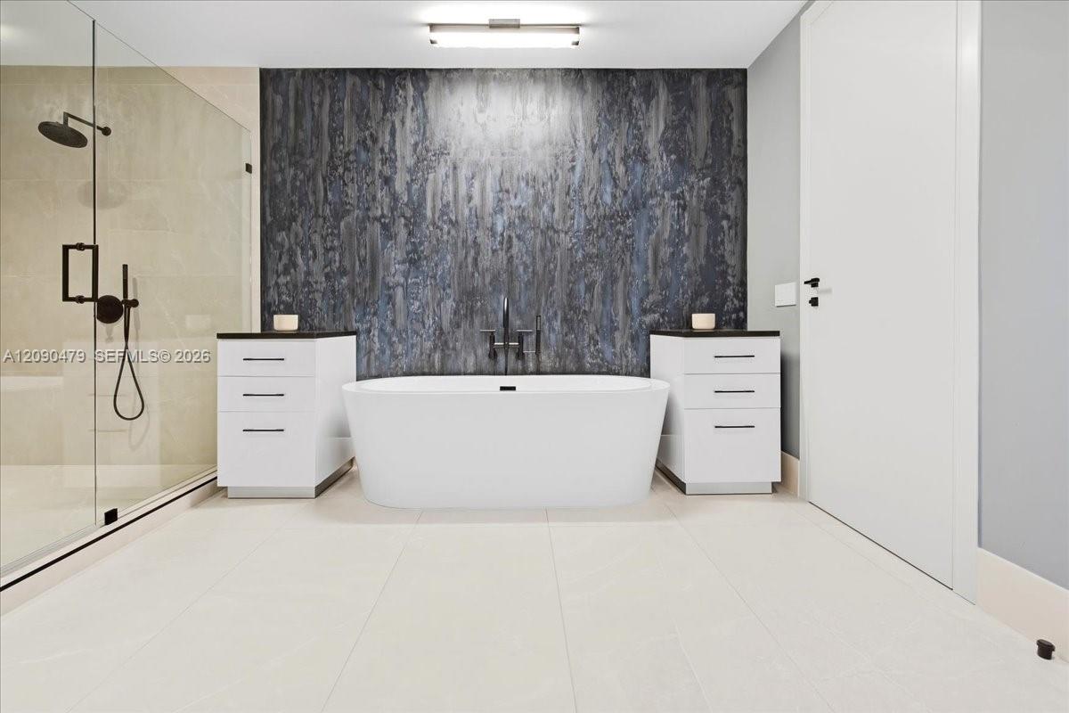 Modern bathroom with a freestanding tub, glass shower, and dark textured accent wall.