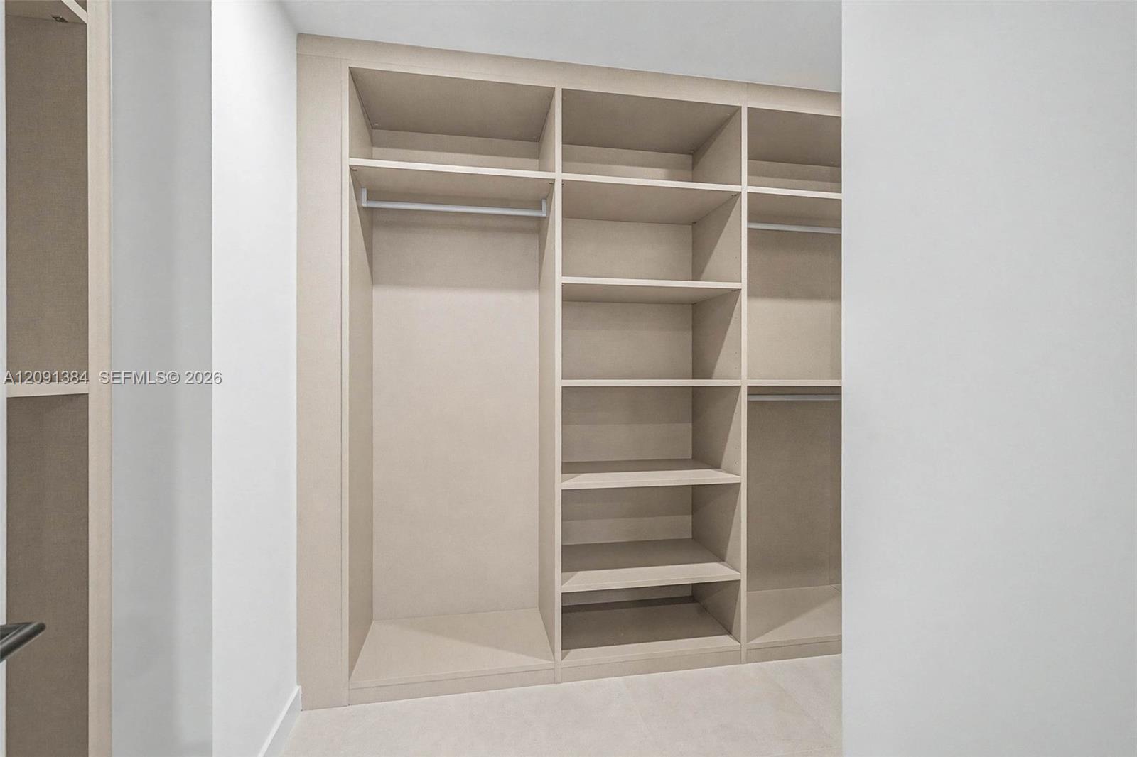 Built-in closet with open hanging space and rows of shelving.