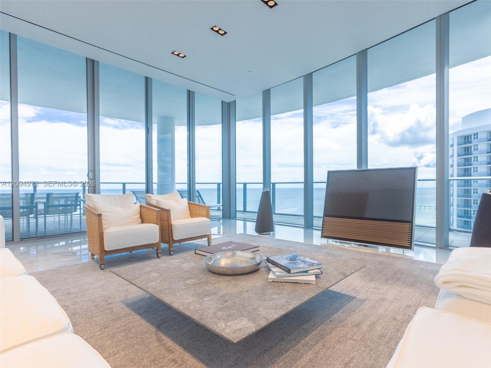 Modern living room with floor-to-ceiling windows overlooking the ocean.