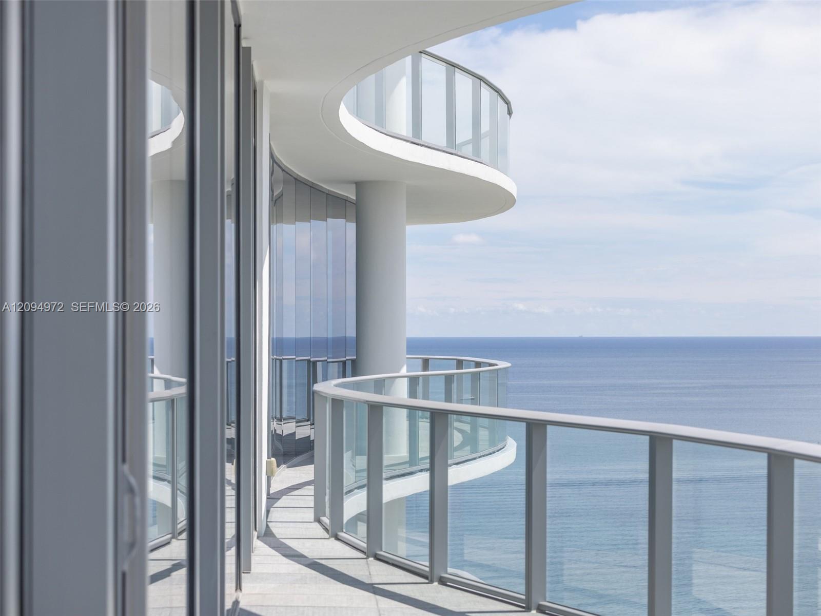 Curved glass balcony overlooking the ocean.