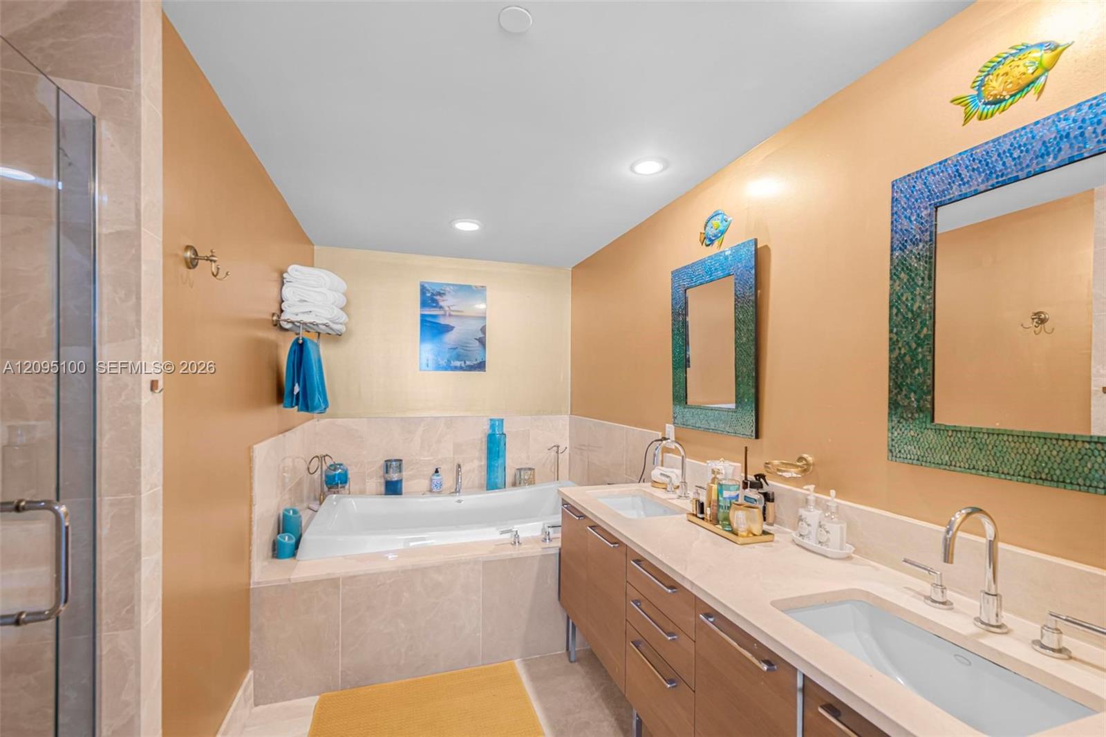 Bathroom with a built-in soaking tub, glass shower, and long double-sink vanity.