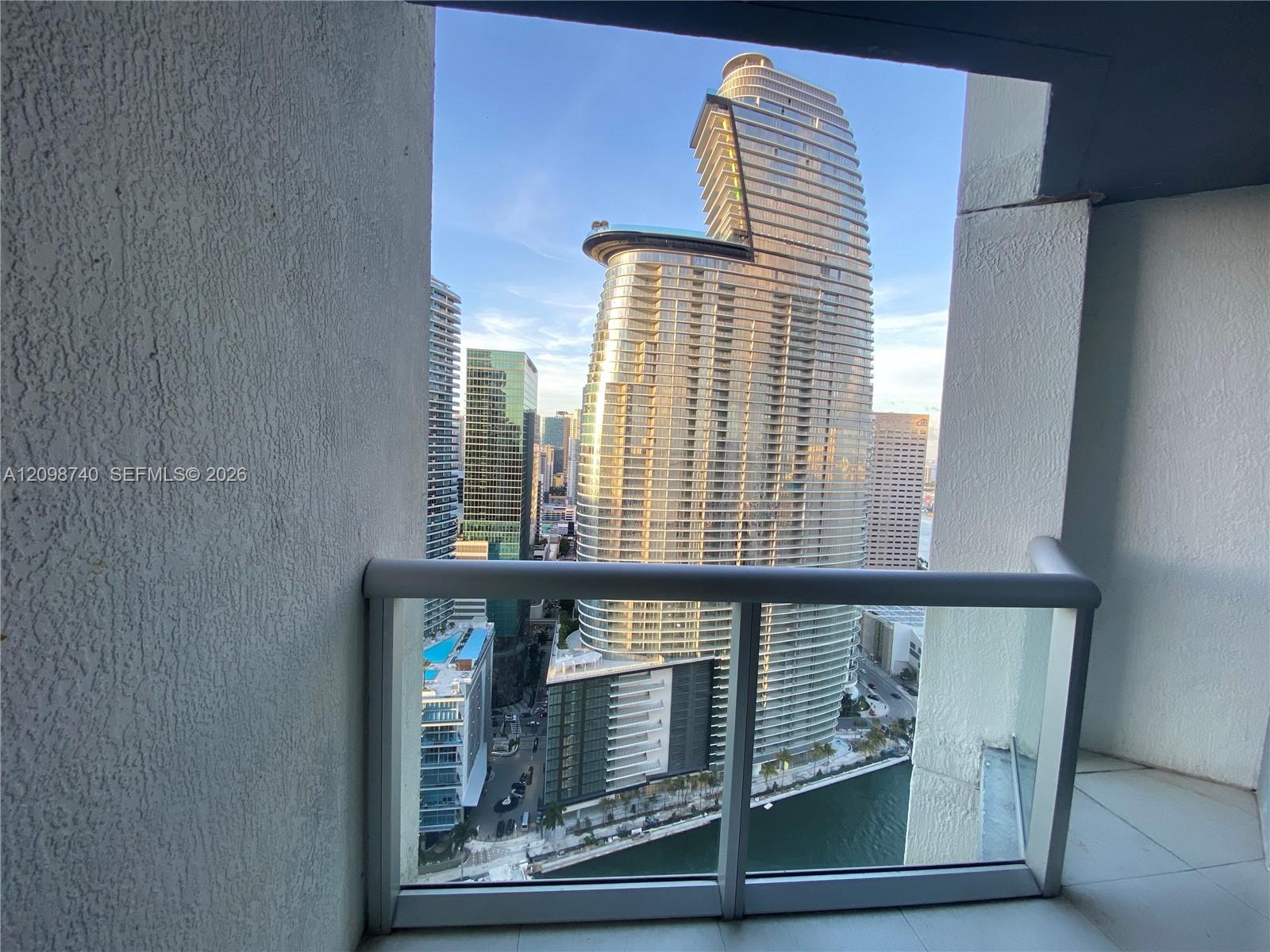 Miami skyline and waterfront viewed from a tiled high-rise balcony.