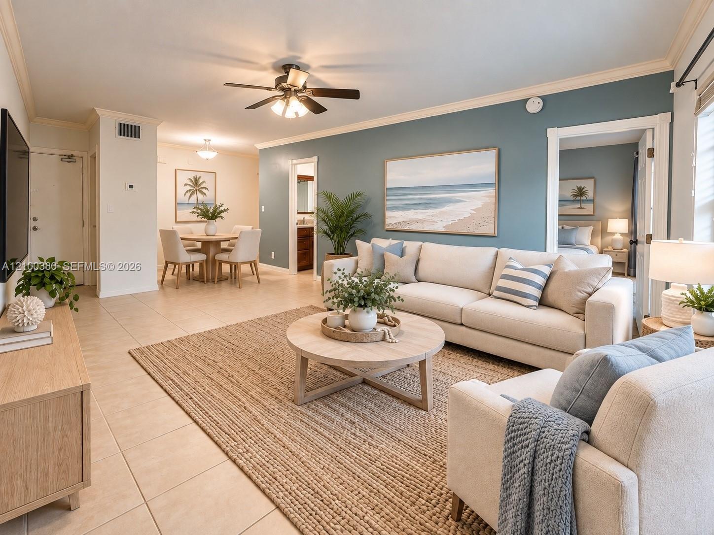 Staged condo living room with cream sofas, a blue accent wall, and an adjoining dining area.