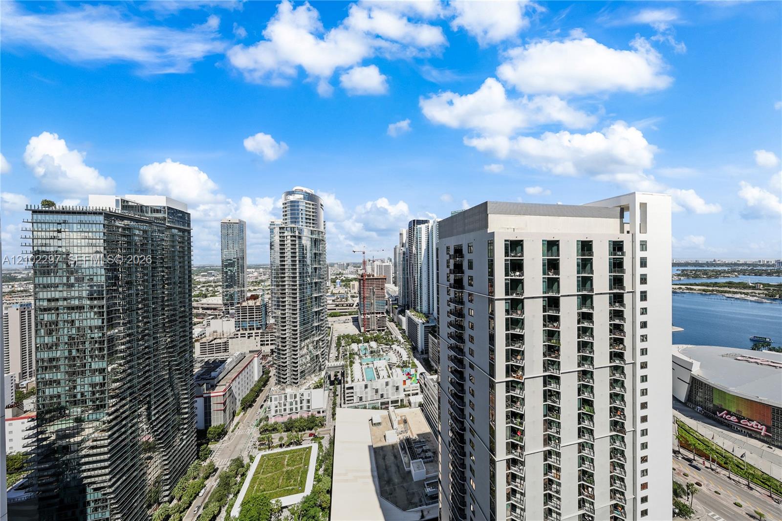 Downtown high-rises viewed from above, with the bay visible beyond the buildings.