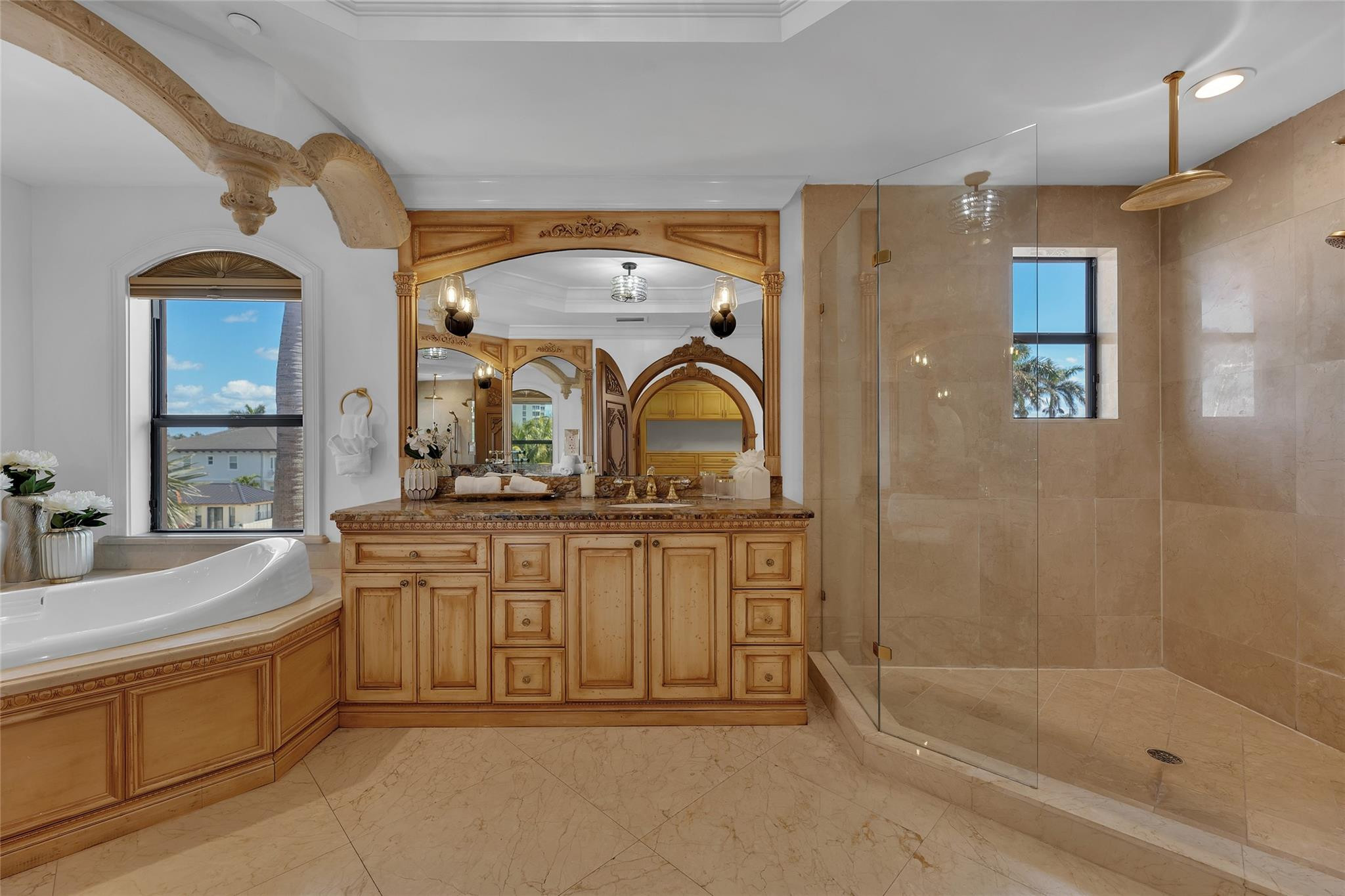 Bathroom with a soaking tub, glass shower, and ornate carved wood vanity.