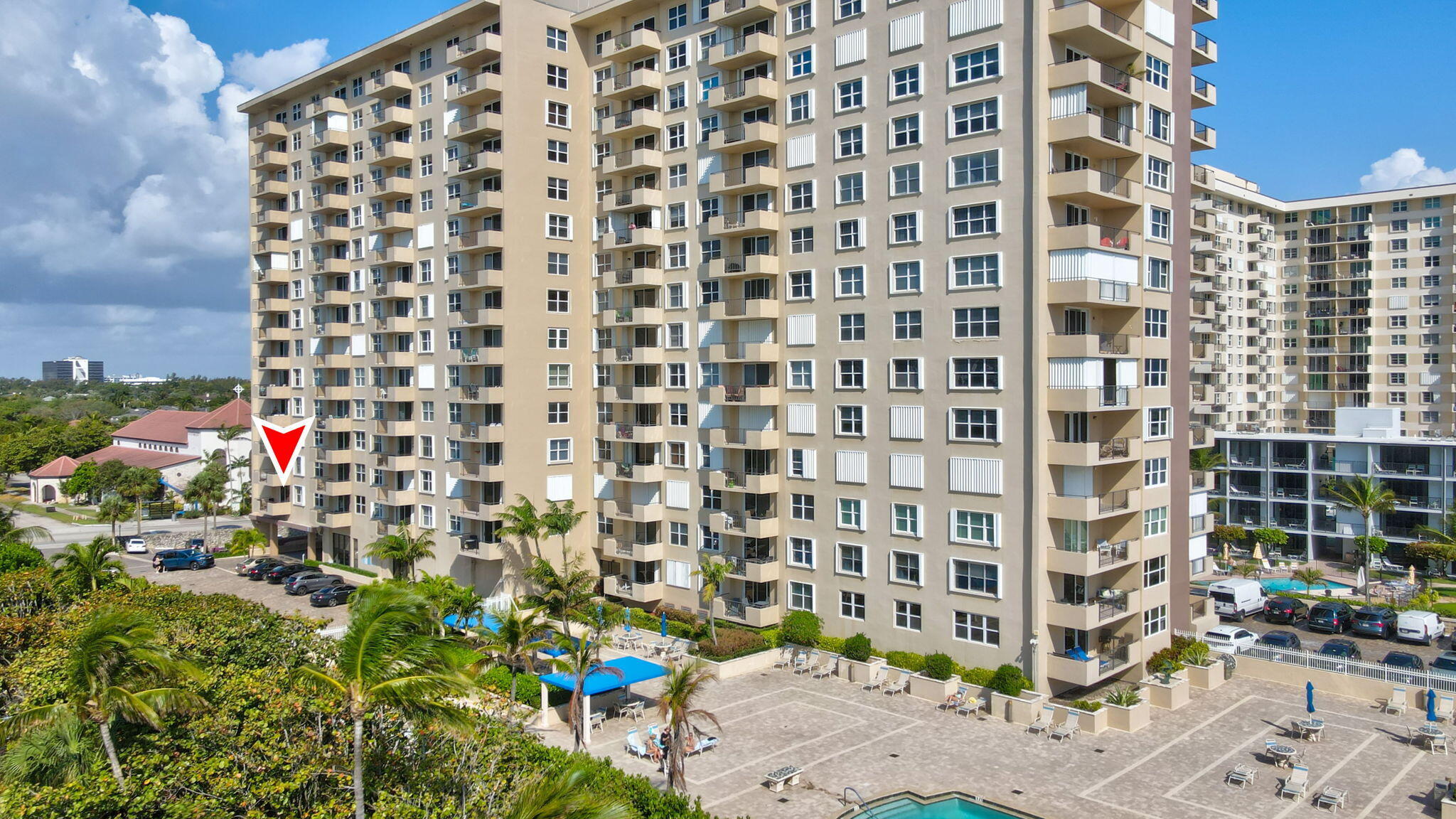 High-rise condominium with a red arrow marking a unit above the pool deck.