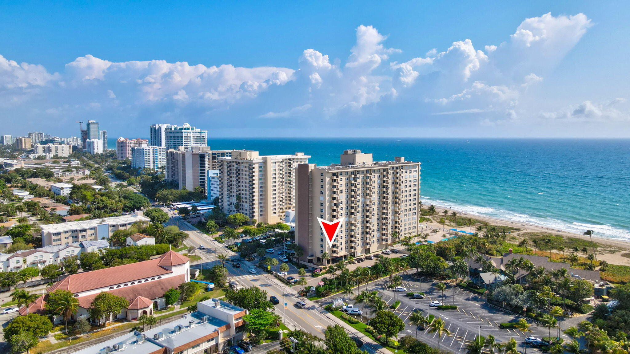 Aerial view of the marked oceanfront condominium beside the beach and Atlantic Ocean.