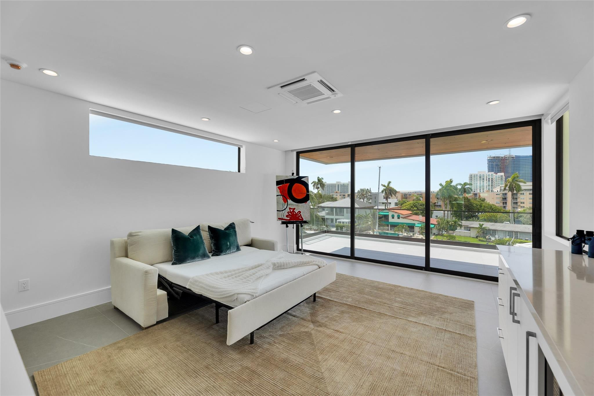 Furnished living room with floor-to-ceiling glass doors, a balcony, and city views.