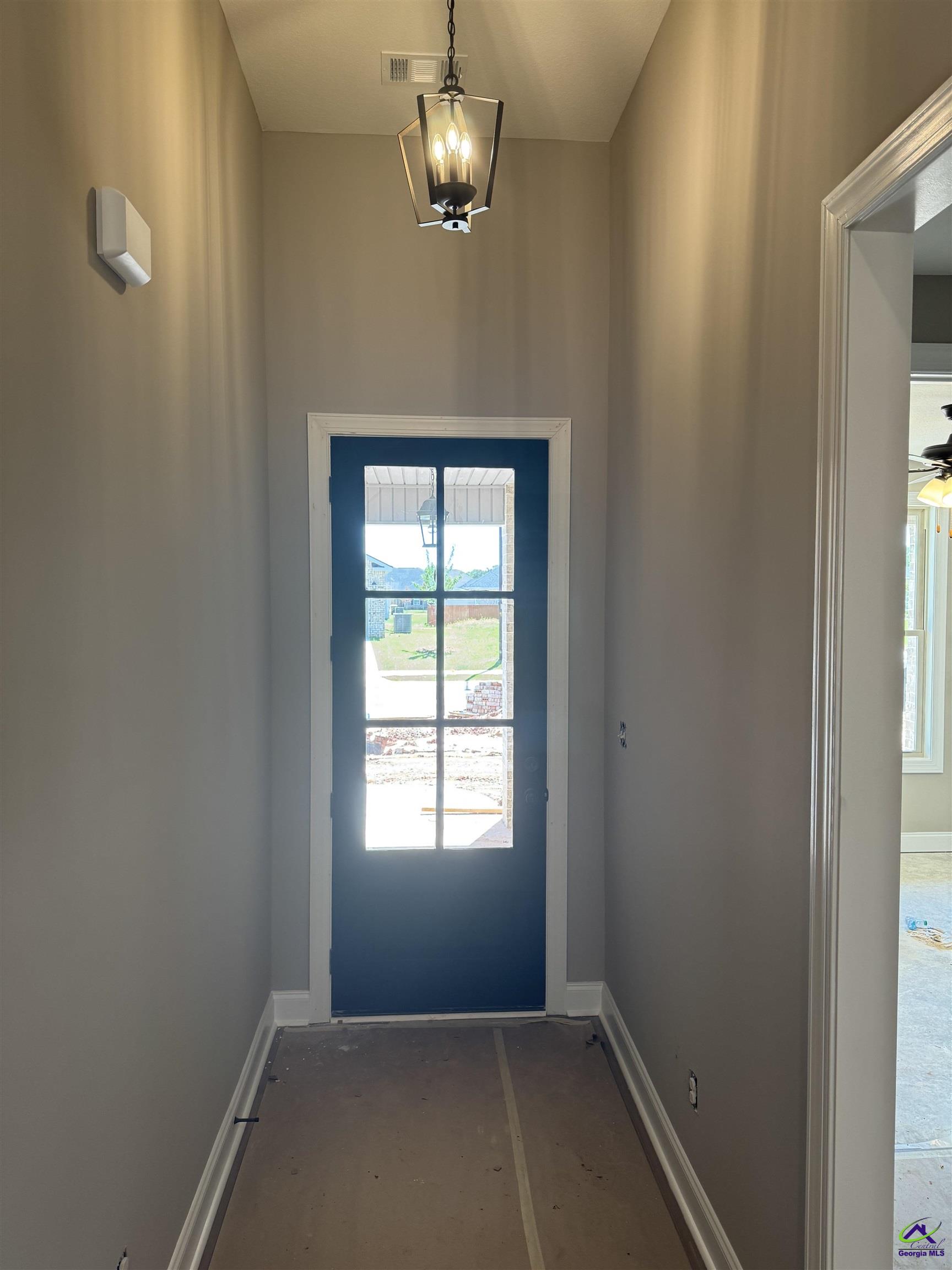 Entry foyer with a dark blue glass-paneled front door and hanging lantern.
