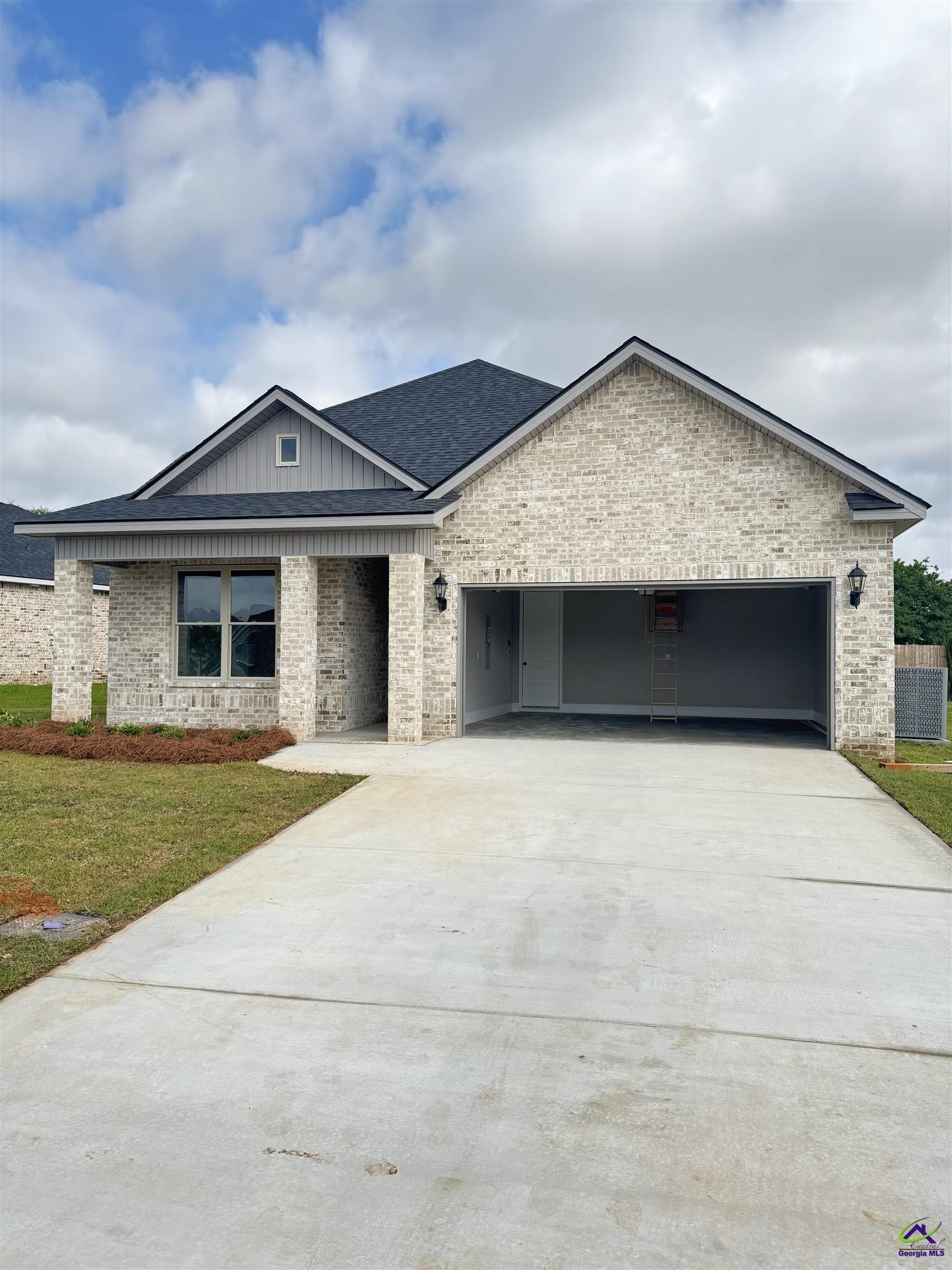 419 Otter's Ridge Drive with light brick exterior, open two-car garage, and broad concrete driveway.