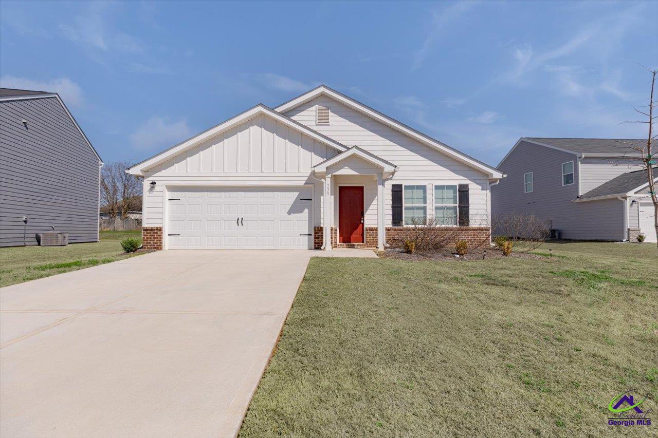 White single-story house with a red front door, brick accents, and an attached garage.