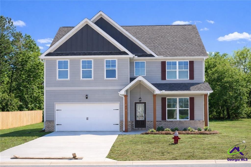 Two-story gray home with a front gable, white garage, and wide driveway.