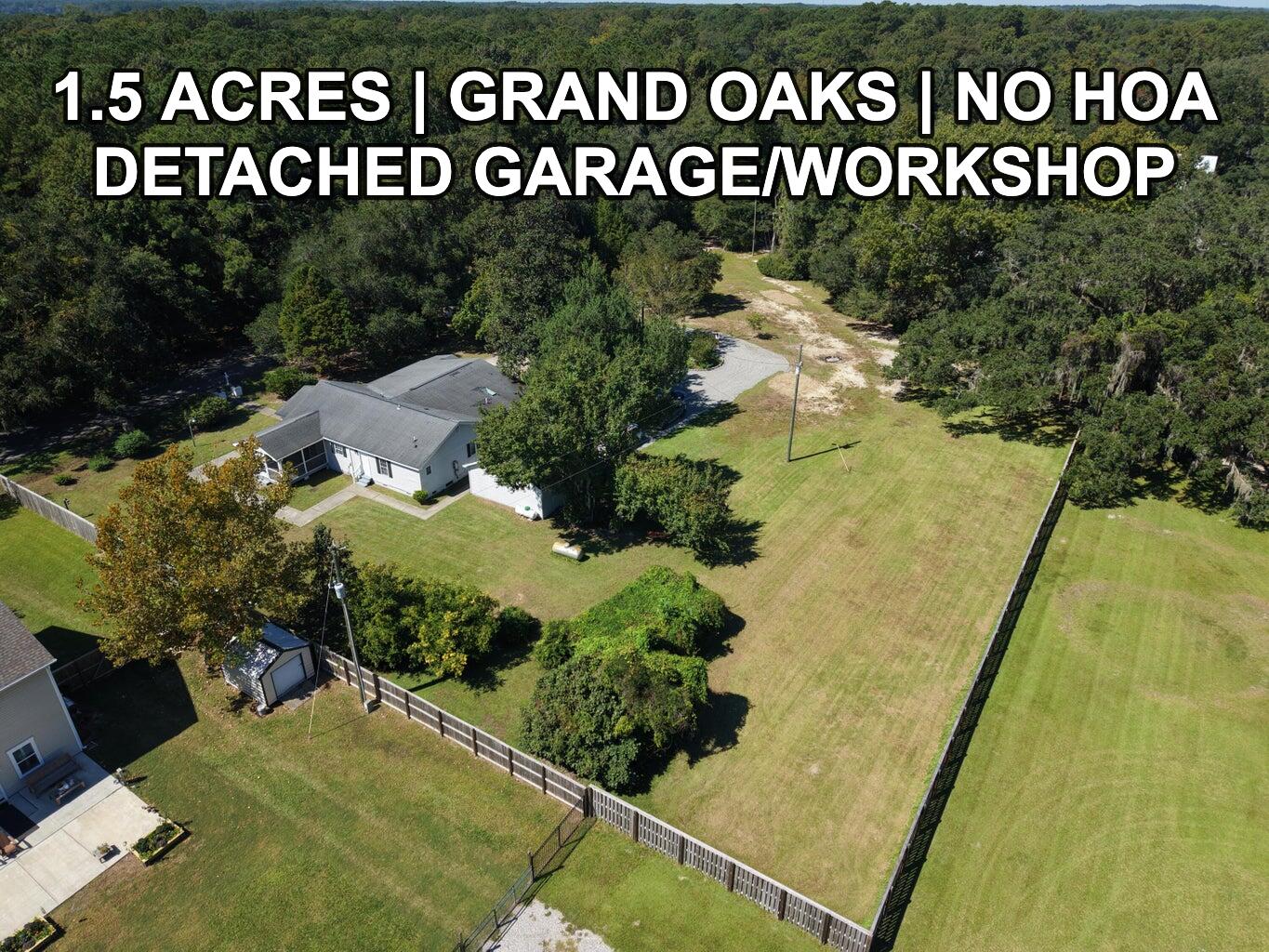 House on a large tree-lined lot with a detached outbuilding and broad fenced lawn.