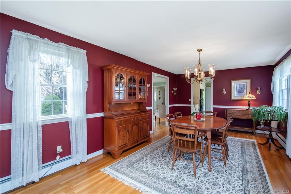 Dining room with red walls, a wooden dining set, china cabinet, and patterned rug.