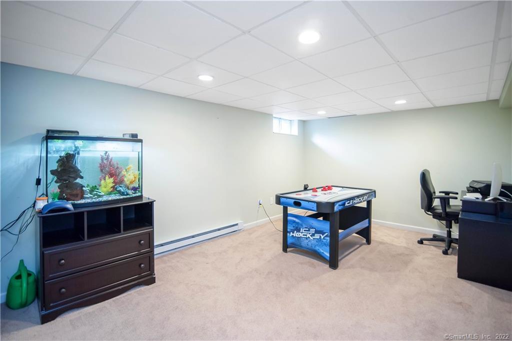 Basement recreation room with an air hockey table, aquarium, and office chair.