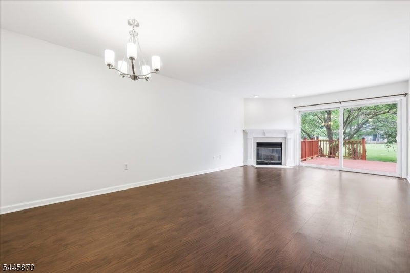 Empty living room with a fireplace and sliding glass doors opening onto a deck.