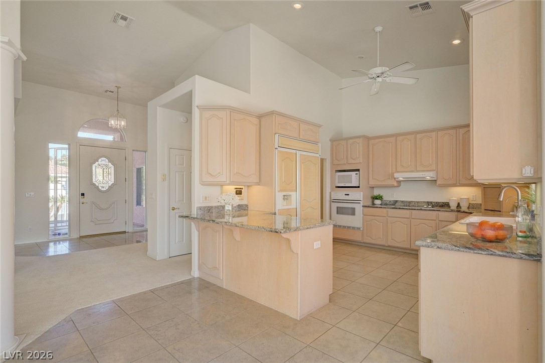 Spacious kitchen with light wood cabinets, granite counters, and a central island.