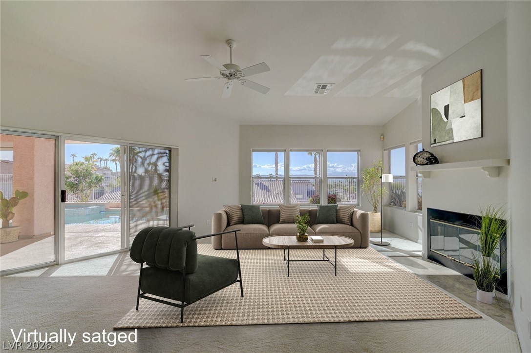 Virtually staged living room with a sofa, fireplace, and sliding doors overlooking a pool.